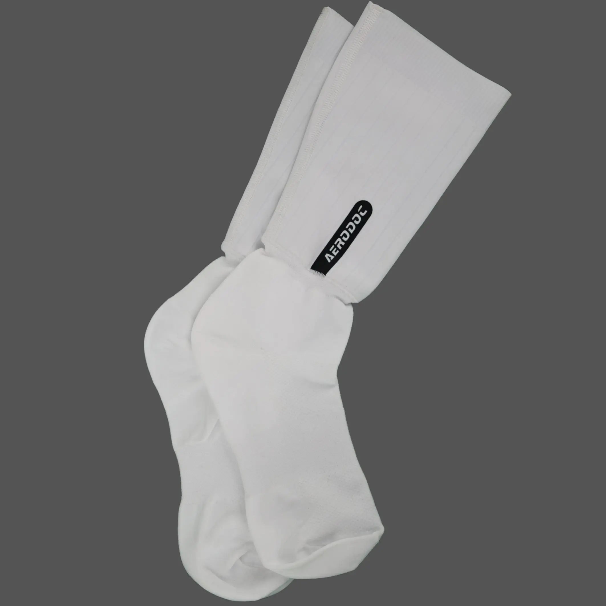 A pair of white crew socks with a black 'AERODOLS' brand tag on the leg, displayed against a solid dark gray background.