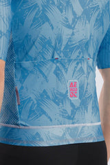 Close-up of a blue patterned cycling jersey with a front pocket and a visible AERODOC logo patch, worn by a model.
