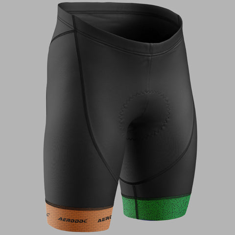 Black cycling shorts with a green textured band at the lower right hem and an orange textured band at the lower left hem, featuring the AERODOC brand name printed on the orange band.