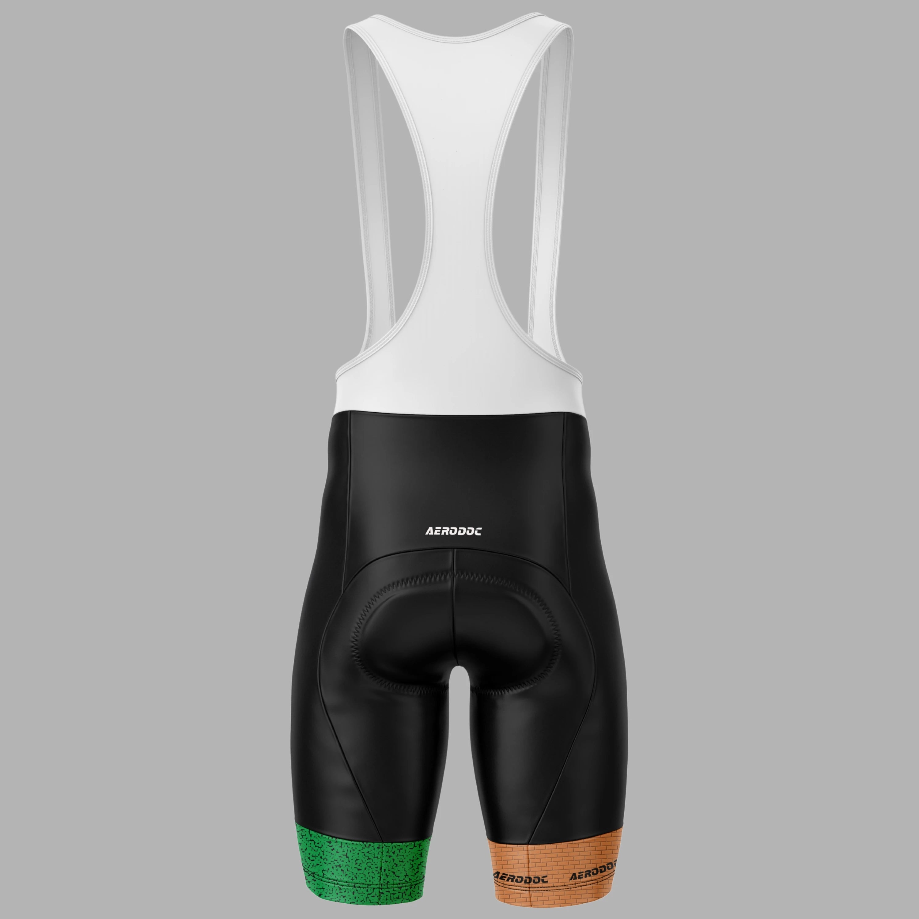 Rear view of a cycling bib short with a white upper section and black lower section, featuring green and brown textured accents at the bottom hems, on a solid gray background.