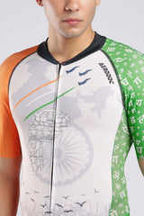 A close-up of a man wearing a short-sleeve athletic cycling or triathlon onepiece with a patriotic Indian theme. The jersey features a white center with a faint map of India and the Ashoka Chakra, an orange sleeve on the left, a green sleeve on the right with Devanagari script, and thin orange, white, and green .