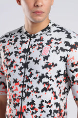 A close-up of a male cyclist wearing a short-sleeve cycling jersey with a white base, black digital camouflage pattern, and red accents. The jersey features a full front zipper 