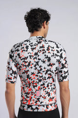 Aerodoc Rear view of a man wearing a short-sleeve cycling jersey with a black, white, and red digital camouflage pattern, set against a light gray studio background.