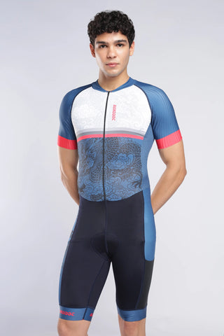 A male model wearing a AERODOC trisuit . The tyrisuit features a white upper chest, blue sleeves, a blue patterned midsection, and red accents on the cuffs and collar.