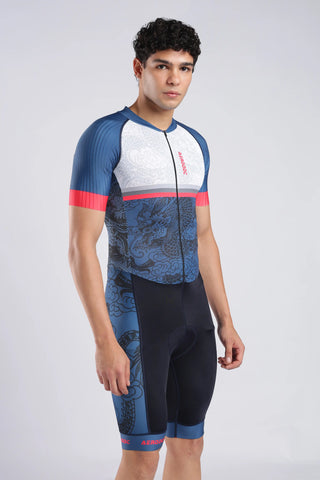 A close-up of a man wearing a short-sleeve tyrisuit with a white upper section, blue lower section, and dragon pattern. The aerodoc trisuit features a vertical red 'AERODOC' logo on the chest.